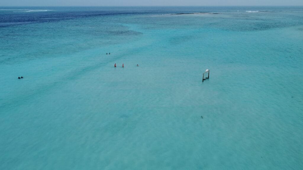 Aerial view of the stunning ocean surrounding Gulhi, Maldives, showcasing vibrant blue waters and serene waves.