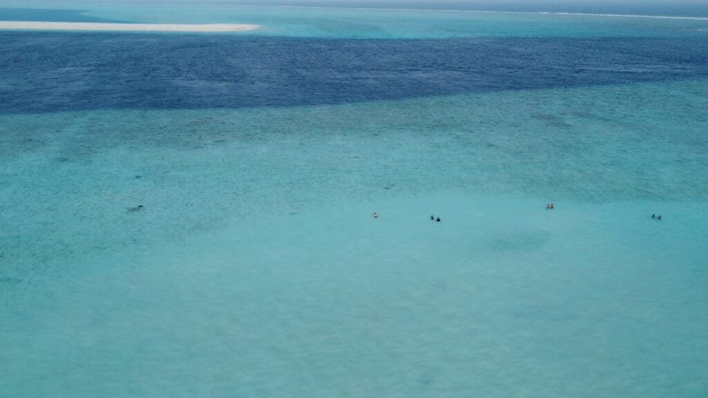 Eine Gruppe von Menschen, die im klaren Wasser der Insel Gulhi auf den Malediven schwimmen.