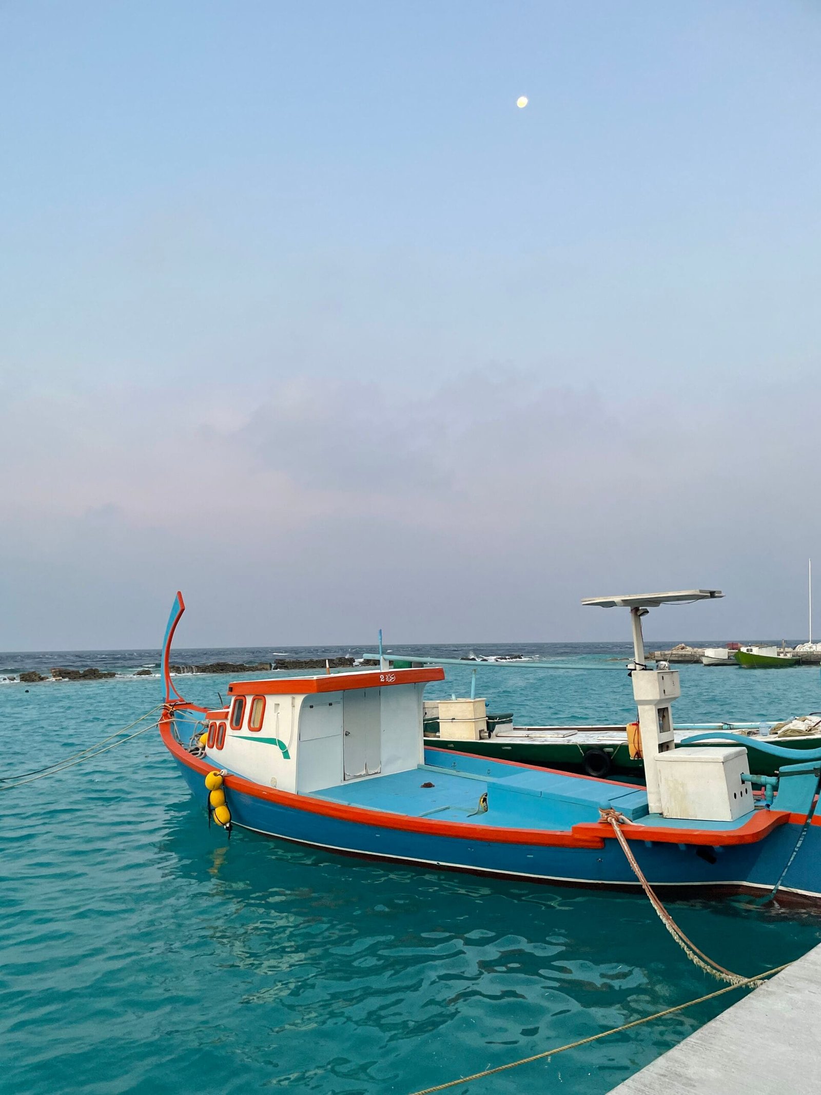 Ein Fischerboot im Wasser vor Omadhoo