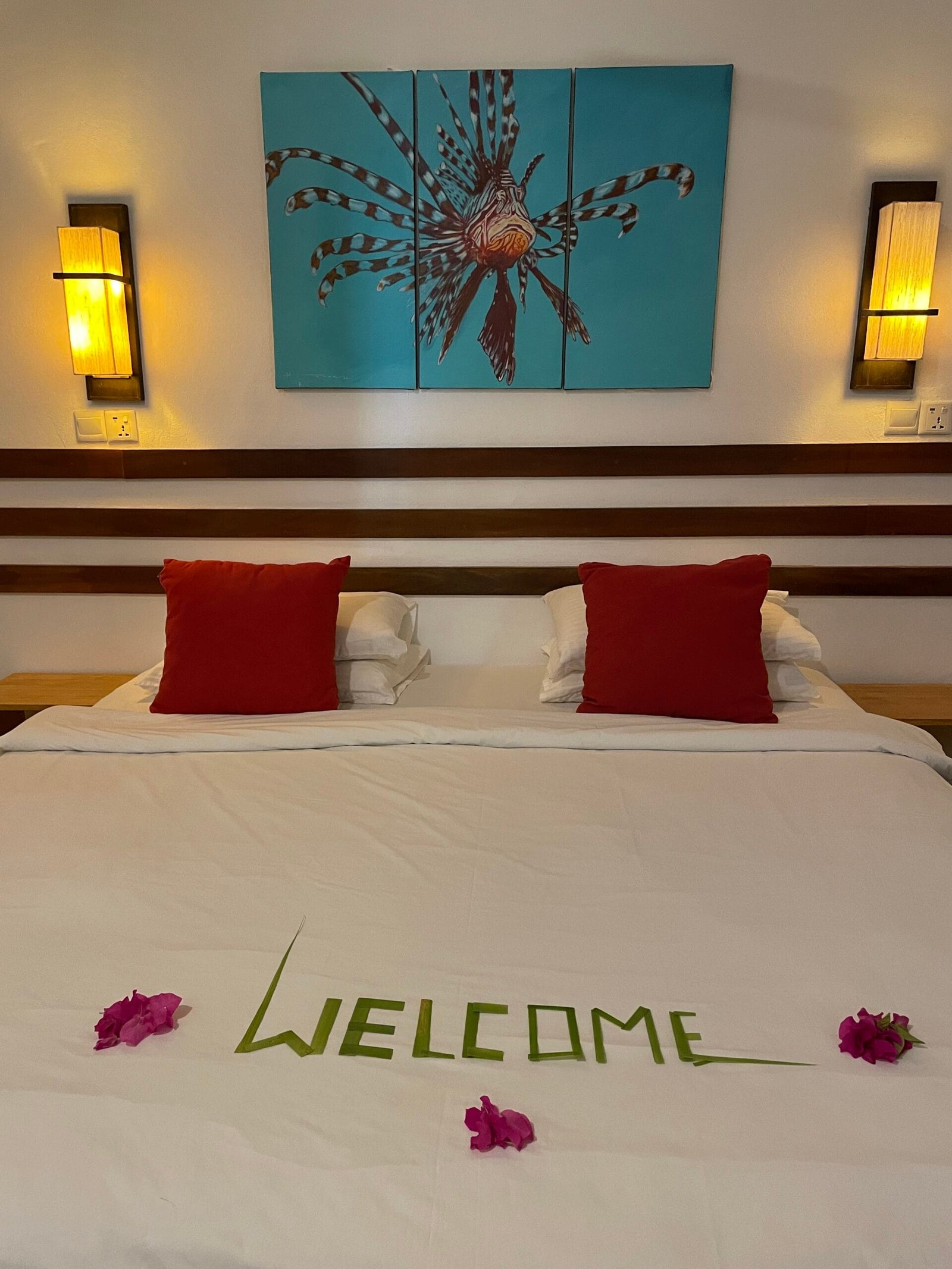 A cozy bed adorned with a welcome sign, set in the beautiful Maldives, Omadhoo. Perfect for a relaxing getaway!
