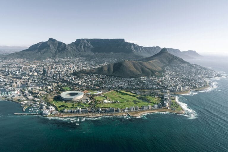 A wide angle picture of cape town with the stadium and table mountain in the background